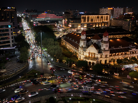 Aerial view of the illuminated historic Lawang Sewu building at night with busy traffic light trails on the surrounding streets in Semarang Central Java Indonesia. Aerial view of the illuminated historic Lawang Sewu building at night with busy traffic light trails on the surrounding streets in Semarang Central Java Indonesia.