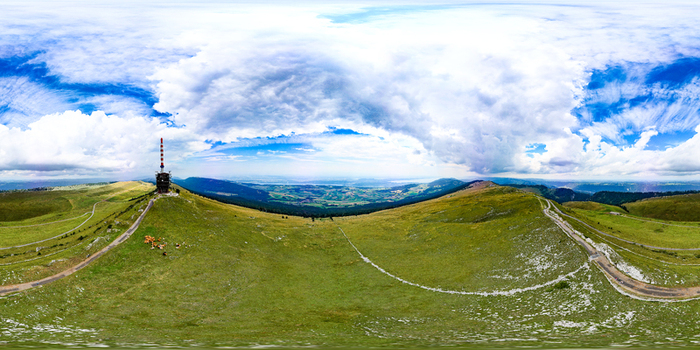 Aerial view of the Chasseral telecommunications tower on a green mountain ridge under a dramatic cloudy sky Nods Canton of Bern Switzerland. Aerial view of the Chasseral telecommunications tower on a green mountain ridge under a dramatic cloudy sky Nods Canton of Bern Switzerland.