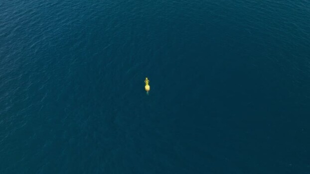 Aerial view of a yellow buoy in the Mediterranean sea Italy.