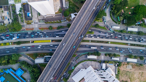 Aerial view of a busy highway interchange with multi level roads and heavy traffic flowing through the urban landscape of Jakarta Indonesia.