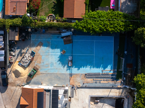 Aerial view of a tennis court undergoing renovation with construction materials and equipment visible in Los Angeles California United States. Aerial view of a tennis court undergoing renovation with construction materials and equipment visible in Los Angeles California United States.