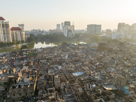 Aerial view of low rise buildings contrasting with distant skyscrapers and a serene lake reflecting the morning light Dhaka Dhaka Division Bangladesh. Aerial view of low rise buildings contrasting with distant skyscrapers and a serene lake reflecting the morning light Dhaka Dhaka Division Bangladesh.