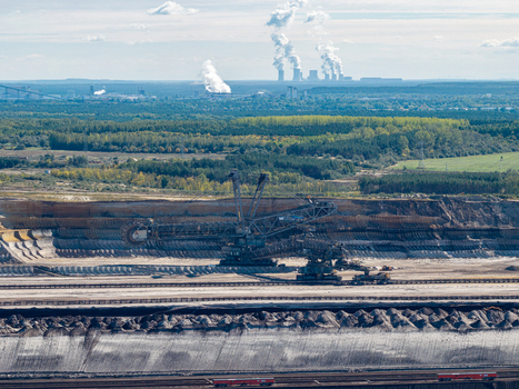 Aerial view of the Tagebau Welzow Sud brown coal open pit mine with a massive bucket wheel excavator industrial landscape and distant power plant in Spremberg Brandenburg Germany. Aerial view of the Tagebau Welzow Sud brown coal open pit mine with a massive bucket wheel excavator industrial landscape and distant power plant in Spremberg Brandenburg Germany.