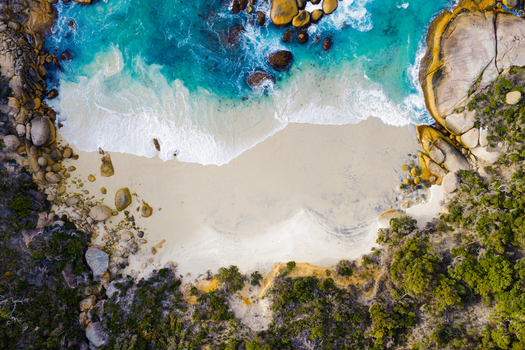 Aerial view of Two Peoples Bay Nature Reserve featuring turquoise water white sand beach and rocky coastline in Albany Western Australia Australia.