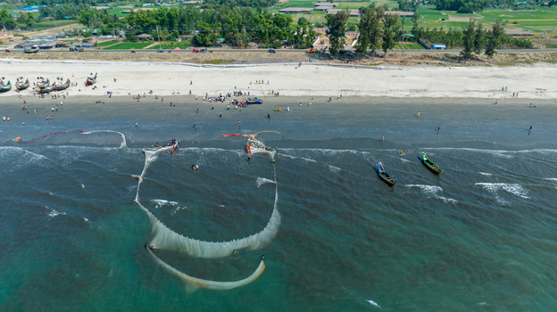 Aerial view of fishing nets cast out into the sea contrasting with the sandy beach and distant buildings Cox s Bazar Chittagong Division Bangladesh. Aerial view of fishing nets cast out into the sea contrasting with the sandy beach and distant buildings Cox s Bazar Chittagong Division Bangladesh.
