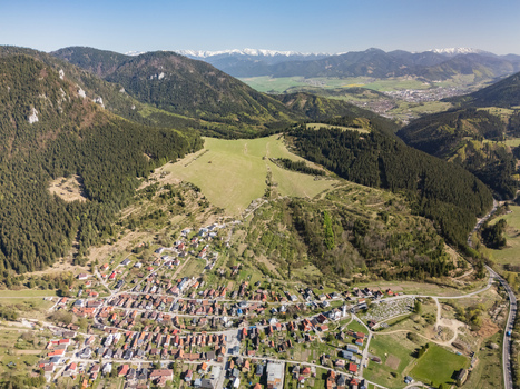 Aerial view of the historic village of Valaska Dubova surrounded by forested hills and distant snow capped peaks Valaska Dubova Zilina Region Slovakia. Aerial view of the historic village of Valaska Dubova surrounded by forested hills and distant snow capped peaks Valaska Dubova Zilina Region Slovakia.