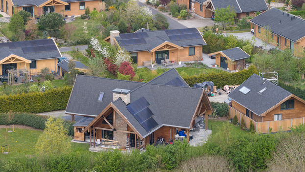 Aerial view of the wooden houses of Ecodorp Bolderburen featuring solar panels on dark roofs and lush green gardens in Almere Flevoland Netherlands. Aerial view of the wooden houses of Ecodorp Bolderburen featuring solar panels on dark roofs and lush green gardens in Almere Flevoland Netherlands.