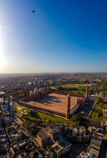 Aerial view of Badshahi Mosque with its large courtyard minarets and surrounding historic urban landscape in Lahore Punjab Pakistan. Aerial view of Badshahi Mosque with its large courtyard minarets and surrounding historic urban landscape in Lahore Punjab Pakistan.