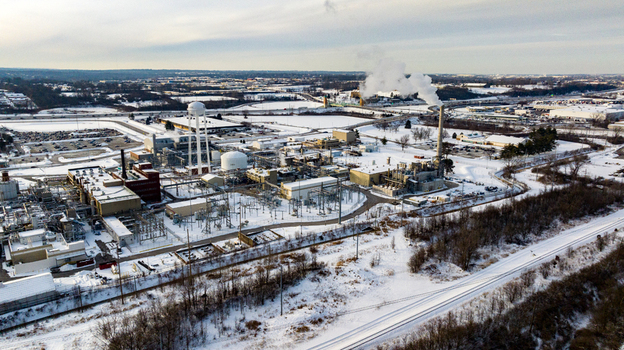 Aerial view of an industrial facility with smoking chimneys and snow covered grounds under an overcast winter sky Reading Ohio United States. Aerial view of an industrial facility with smoking chimneys and snow covered grounds under an overcast winter sky Reading Ohio United States.