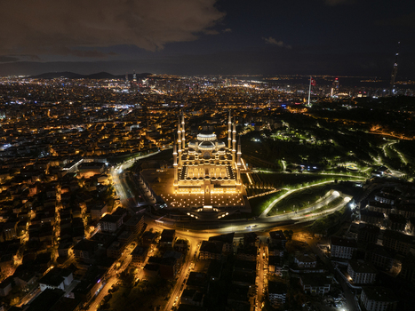Aerial view of the illuminated Grand Camlica Mosque at night surrounded by the sprawling urban landscape and glowing city lights of Uskudar Istanbul Turkiye. Aerial view of the illuminated Grand Camlica Mosque at night surrounded by the sprawling urban landscape and glowing city lights of Uskudar Istanbul Turkiye.