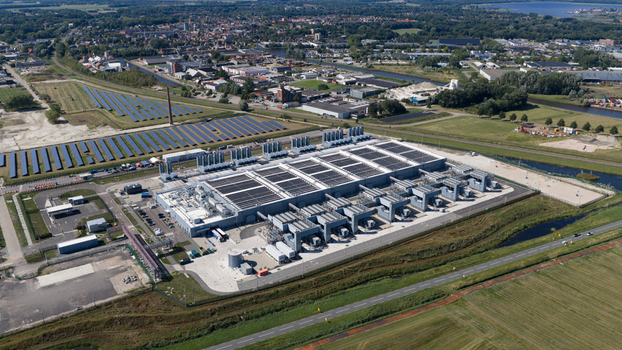 Aerial view of the HGB data center facility surrounded by solar panel arrays green fields and industrial infrastructure in Winschoten Groningen Netherlands.