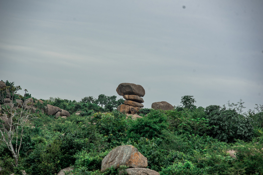 View of a unique balanced rock formation surrounded by lush green vegetation and rocky terrain in Jos North Plateau Nigeria. View of a unique balanced rock formation surrounded by lush green vegetation and rocky terrain in Jos North Plateau Nigeria.