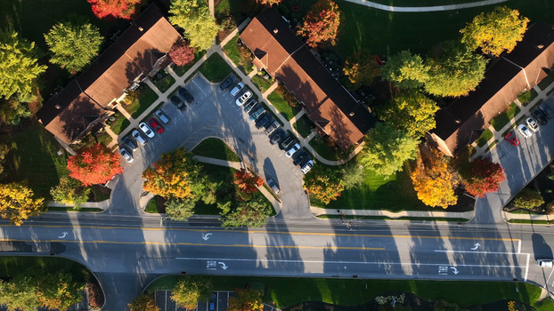 Aerial view of residential buildings surrounded by vibrant autumn trees and parking lots in East Lampeter Township Pennsylvania United States.