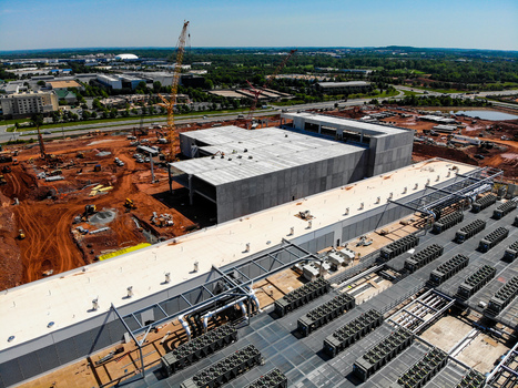 Aerial view of a large data center construction site with concrete structures cranes and HVAC units Ashburn Virginia United States. Aerial view of a large data center construction site with concrete structures cranes and HVAC units Ashburn Virginia United States.