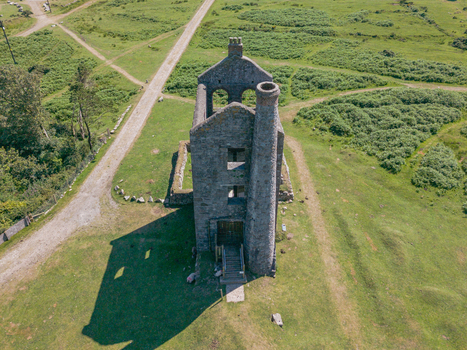 Aerial view of the historic Phoenix United Mine engine house surrounded by grassy moorland and winding paths in Minions Cornwall United Kingdom. Aerial view of the historic Phoenix United Mine engine house surrounded by grassy moorland and winding paths in Minions Cornwall United Kingdom.