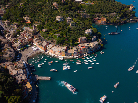 Aerial view of the colorful buildings and luxury yachts in the harbor of Portofino surrounded by lush green hills Portofino Liguria Italy.