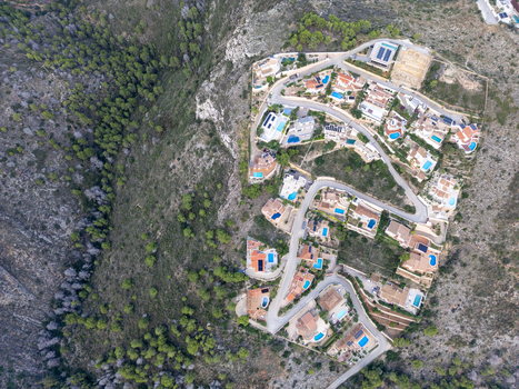 Aerial view of residential villas with swimming pools nestled on a hillside in Moraira Valencian Community Spain.