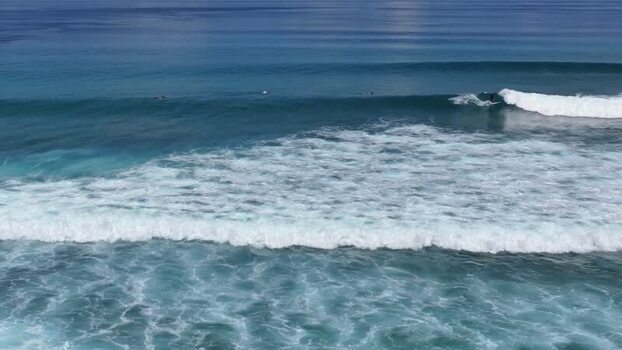 Aerial view of surfers riding waves in the ocean Maldives.