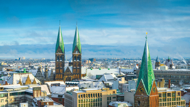 Aerial view of St. Peter s Cathedral with its distinctive green spires rising above the snow covered rooftops of Bremen Germany. Aerial view of St. Peter s Cathedral with its distinctive green spires rising above the snow covered rooftops of Bremen Germany.