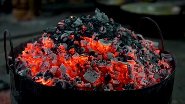 View of glowing red hot charcoal embers in a metal pot Bangladesh. View of glowing red hot charcoal embers in a metal pot Bangladesh.