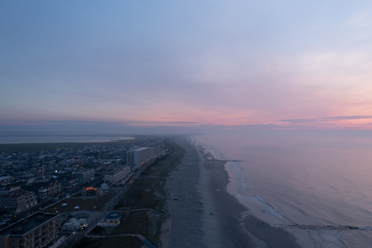 Aerial view of Sea Isle City Beach at sunrise with calm ocean waves sandy coastline and coastal buildings in Sea Isle City New Jersey United States.