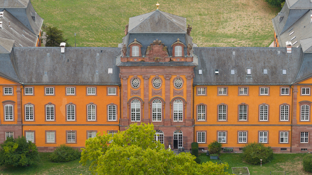 Aerial view of Chateauform Schloss Lowenstein with its distinctive orange facade and historic architecture surrounded by green lawns in Kleinheubach Bayern Germany. Aerial view of Chateauform Schloss Lowenstein with its distinctive orange facade and historic architecture surrounded by green lawns in Kleinheubach Bayern Germany.