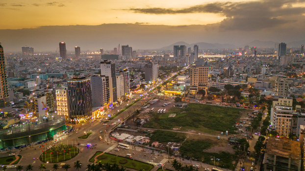 Aerial view of Da Nang cityscape at sunset with modern buildings busy streets and glowing lights under a warm sky Da Nang Vietnam. Aerial view of Da Nang cityscape at sunset with modern buildings busy streets and glowing lights under a warm sky Da Nang Vietnam.