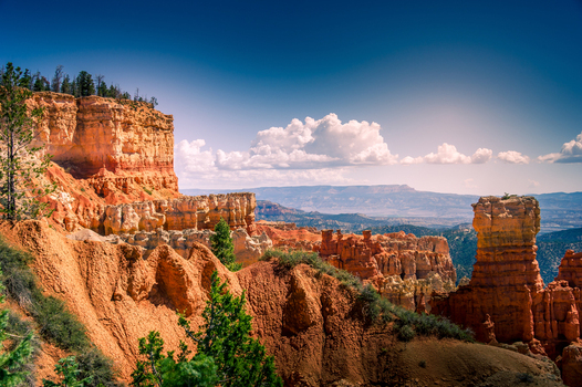 View of Bryce Canyon National Park with its iconic orange hoodoos rocky cliffs and pine trees under a clear blue sky in Utah United States.