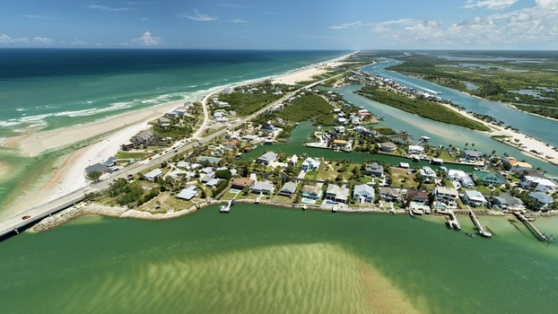 Aerial view of Matanzas Inlet showing the coastal waterway residential homes along the shoreline sandy beaches and the bridge crossing the inlet in St. Johns County Florida United States. Aerial view of Matanzas Inlet showing the coastal waterway residential homes along the shoreline sandy beaches and the bridge crossing the inlet in St. Johns County Florida United States.