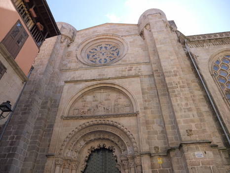 View of the stone facade of the Catedral de Ourense featuring a rose window and intricate arched doorway under a clear blue sky in Ourense Ourense Spain. View of the stone facade of the Catedral de Ourense featuring a rose window and intricate arched doorway under a clear blue sky in Ourense Ourense Spain.