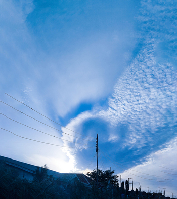 View of a dramatic blue sky with textured clouds and power lines stretching across the horizon in Jos North Plateau Nigeria.