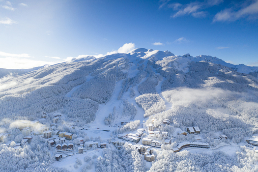 Aerial view of Cerreto Laghi ski resort with snow covered mountains ski slopes and alpine buildings under a clear blue sky in Cerreto Laghi Emilia Romagna Italy. Aerial view of Cerreto Laghi ski resort with snow covered mountains ski slopes and alpine buildings under a clear blue sky in Cerreto Laghi Emilia Romagna Italy.
