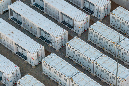 Poland 16 July 2026 Aerial view of a battery energy storage system featuring rows of white industrial storage containers arranged in a grid on a gravel surface.