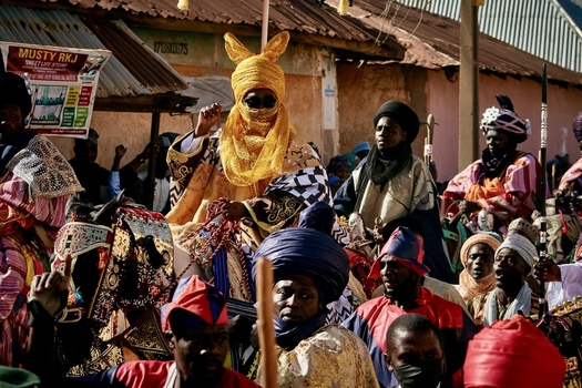 Zaria City Nigeria 21 March 2026 View of a central figure in a striking golden rabbit eared headdress surrounded by a vibrant crowd in rich contrasting traditional attire. Zaria City Nigeria 21 March 2026 View of a central figure in a striking golden rabbit eared headdress surrounded by a vibrant crowd in rich contrasting traditional attire.