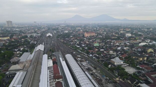 Aerial view of Stasiun Solo Balapan with its railway tracks platforms and surrounding urban landscape under a cloudy sky in Banjarsari Central Java Indonesia. Aerial view of Stasiun Solo Balapan with its railway tracks platforms and surrounding urban landscape under a cloudy sky in Banjarsari Central Java Indonesia.