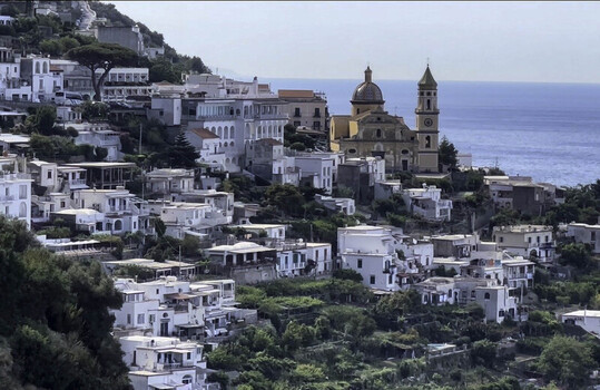 Aerial view of the Church of San Gennaro in Vettica Maggiore overlooking the Mediterranean Sea surrounded by white Mediterranean houses and lush terraced gardens in Amalfi Campania Italy. Aerial view of the Church of San Gennaro in Vettica Maggiore overlooking the Mediterranean Sea surrounded by white Mediterranean houses and lush terraced gardens in Amalfi Campania Italy.