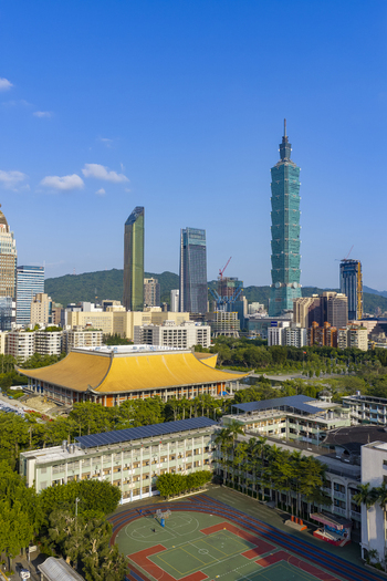 Aerial view of Taipei 101 skyscraper rising above the Sun Yat sen Memorial Hall surrounded by urban buildings lush trees and a basketball court in Taipei Taiwan. Aerial view of Taipei 101 skyscraper rising above the Sun Yat sen Memorial Hall surrounded by urban buildings lush trees and a basketball court in Taipei Taiwan.