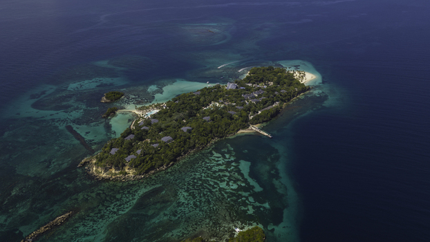 Aerial view of Cayo Levantado Beach surrounded by lush tropical vegetation and vibrant turquoise waters with coral reefs in Samana SAMANA Dominican Republic. Aerial view of Cayo Levantado Beach surrounded by lush tropical vegetation and vibrant turquoise waters with coral reefs in Samana SAMANA Dominican Republic.