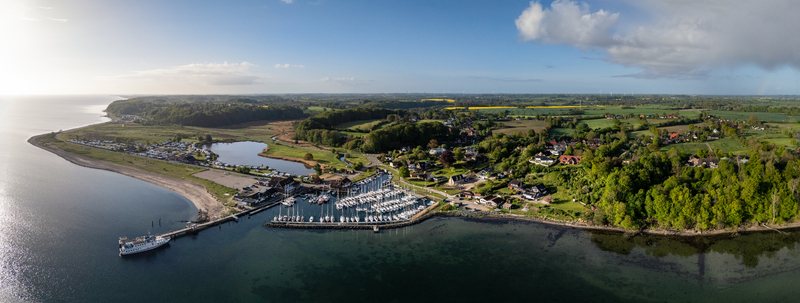 Aerial view of Langballigau harbor with sailboats in the marina a ferry at the pier and lush green coastal landscapes in Schleswig Flensburg Schleswig Holstein Germany.