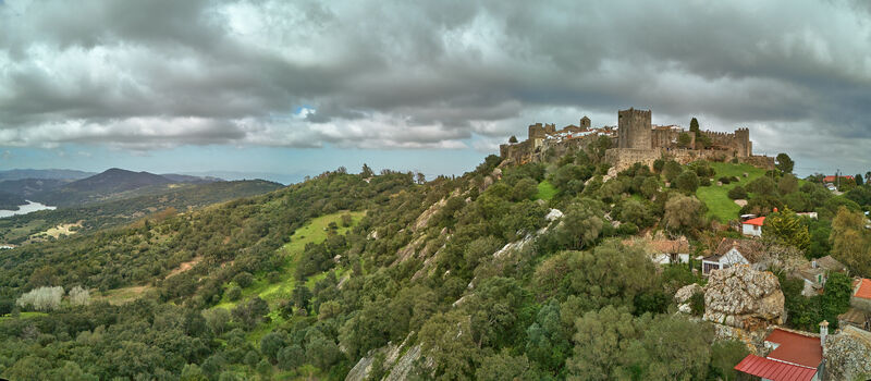 Aerial view of the ancient fortress clinging to the hilltop a tapestry of stone and earth under a brooding sky Castellar de la Frontera Andalucía Spain. Aerial view of the ancient fortress clinging to the hilltop a tapestry of stone and earth under a brooding sky Castellar de la Frontera Andalucía Spain.