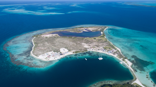Aerial view of Los Roques archipelago with turquoise waters coral reefs and sandy beaches with small boats anchored in the bay Los Roques Dependencias Federale Venezuela. Aerial view of Los Roques archipelago with turquoise waters coral reefs and sandy beaches with small boats anchored in the bay Los Roques Dependencias Federale Venezuela.