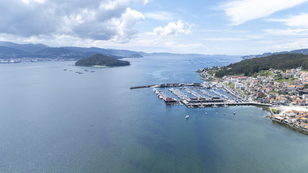 Aerial view of the marina and coastal town of Combarro with the island of Tambo in the Ria de Pontevedra under a cloudy sky Combarro Pontevedra Spain. Aerial view of the marina and coastal town of Combarro with the island of Tambo in the Ria de Pontevedra under a cloudy sky Combarro Pontevedra Spain.