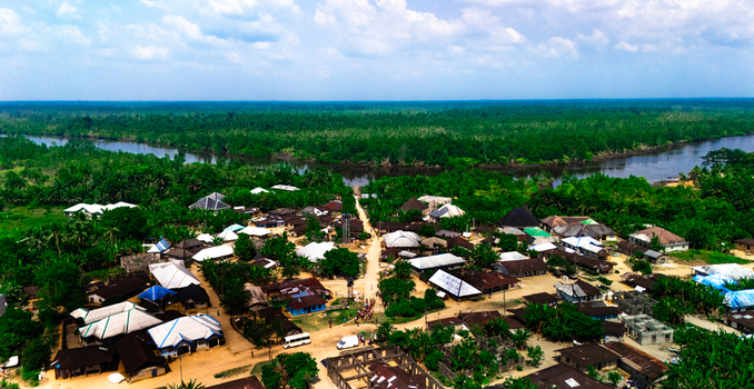 Aerial view of the village of Abua nestled in a lush tropical landscape with dense forests and a winding river under a bright sky in Abua Rivers Nigeria. Aerial view of the village of Abua nestled in a lush tropical landscape with dense forests and a winding river under a bright sky in Abua Rivers Nigeria.