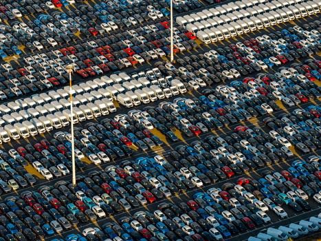 Aerial view of rows of new cars and vans parked in the automotive storage lot at Civitavecchia Port with vehicles arranged in neat lines in Civitavecchia Lazio Italy. Aerial view of rows of new cars and vans parked in the automotive storage lot at Civitavecchia Port with vehicles arranged in neat lines in Civitavecchia Lazio Italy.