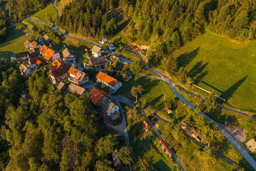 Aerial view of the village of Jamnik with its traditional houses and orange rooftops nestled in the lush green hills of the Kranj region in Jamnik Kranj Slovenia.