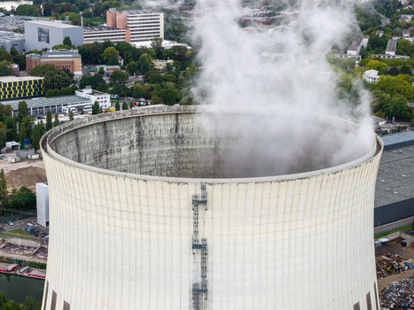 Aerial view of the Heizkraftwerk Reuter West cooling tower emitting steam situated within an industrial area in Berlin Berlin Germany.