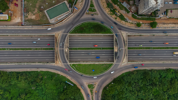 Accra Ghana 02 June 2023 Aerial view of the Forever Roundabout with multi lane highways surrounding greenery and traffic flowing through the intersection. Accra Ghana 02 June 2023 Aerial view of the Forever Roundabout with multi lane highways surrounding greenery and traffic flowing through the intersection.