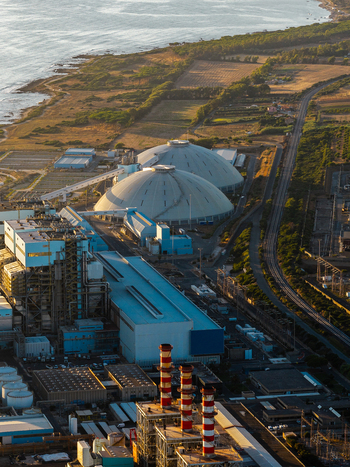 Aerial view of Centrale Termoelettrica Torrevaldaliga Nord power plant featuring large dome structures and striped smokestacks situated along the coastline in Civitavecchia Lazio Italy. Aerial view of Centrale Termoelettrica Torrevaldaliga Nord power plant featuring large dome structures and striped smokestacks situated along the coastline in Civitavecchia Lazio Italy.