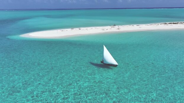 Aerial view of a traditional dhoni sailboat near a white sandbank Maldives. Aerial view of a traditional dhoni sailboat near a white sandbank Maldives.