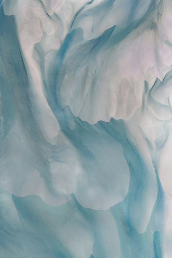 Aerial view of blue glacial ice and snow patterns across the frozen landscape of Senja Troms Norway.